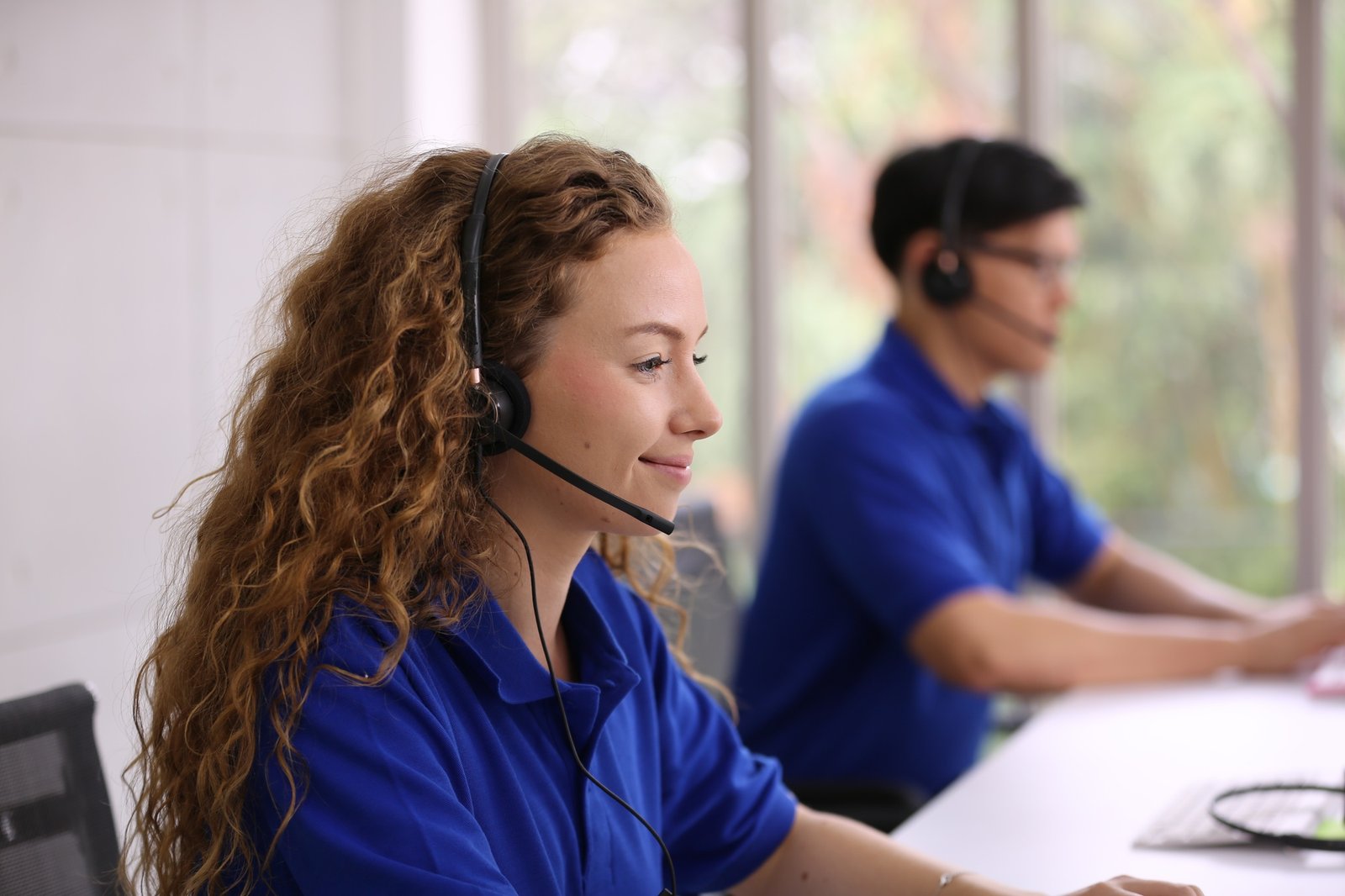 Smiling Woman In Headset Working In Call Center Office